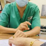 Bác sĩ thăm khám cho người bệnh tại bàn khám