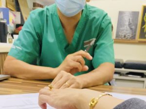 Bác sĩ thăm khám cho người bệnh tại bàn khám