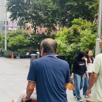 Hỗ trợ người bệnh di chuyển bằng xe lăn trên đường phố Singapore