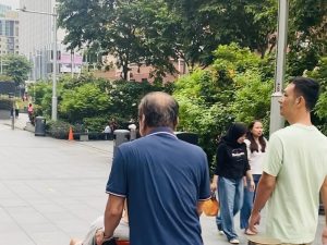 Hỗ trợ người bệnh di chuyển bằng xe lăn trên đường phố Singapore