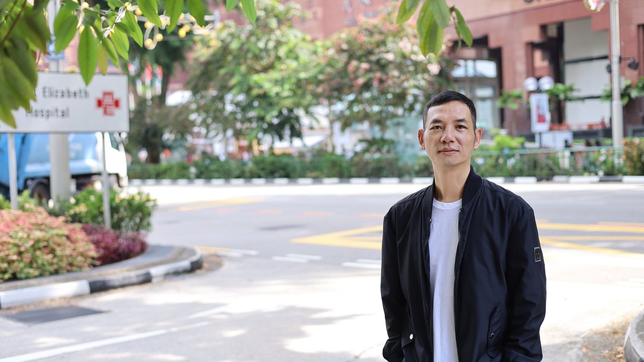 Toàn Lộc đứng trên đường phố Singapore